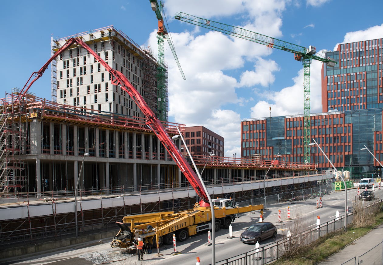 Concrete pump truck delivering concrete to the upper floor of a commercial building under construction