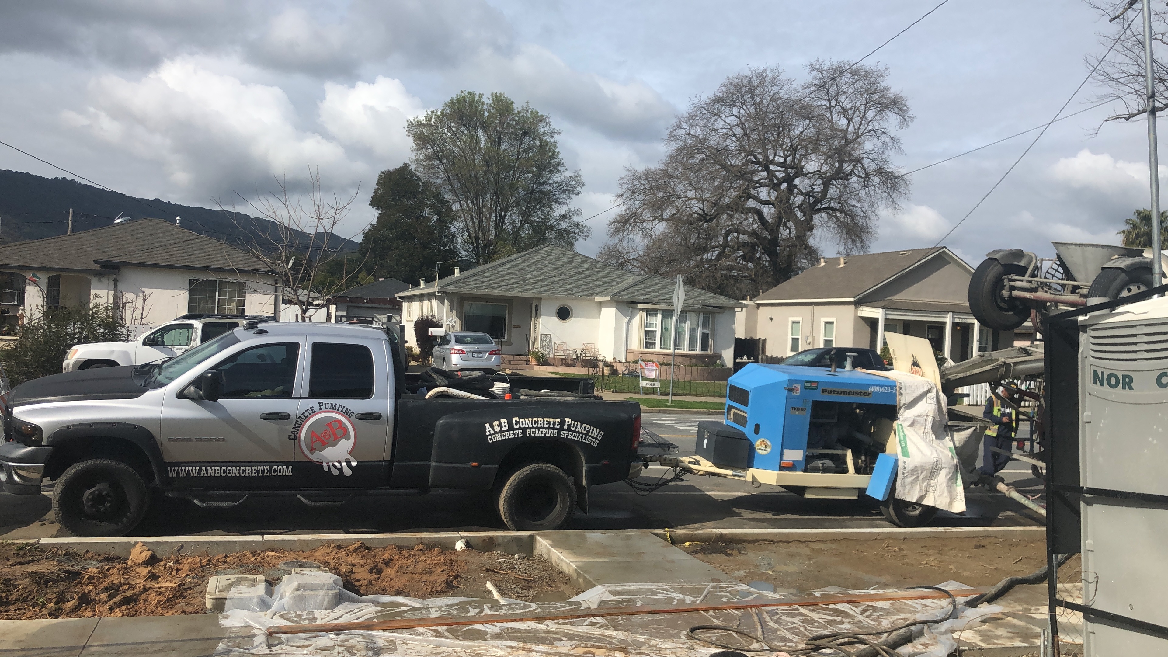 Truck towing concrete pump in residential neighborhood